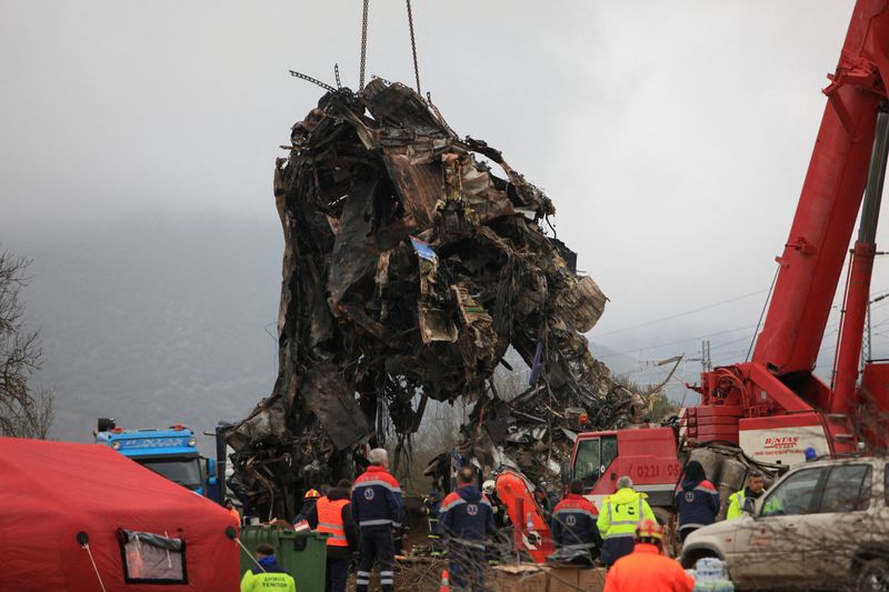 © Reuters. A crane lifts parts of a destroyed carriage as rescuers operate on the site of a crash, where two trains collided, near the city of Larissa, Greece, March 2, 2023. REUTERS/Kostas Mantziaris