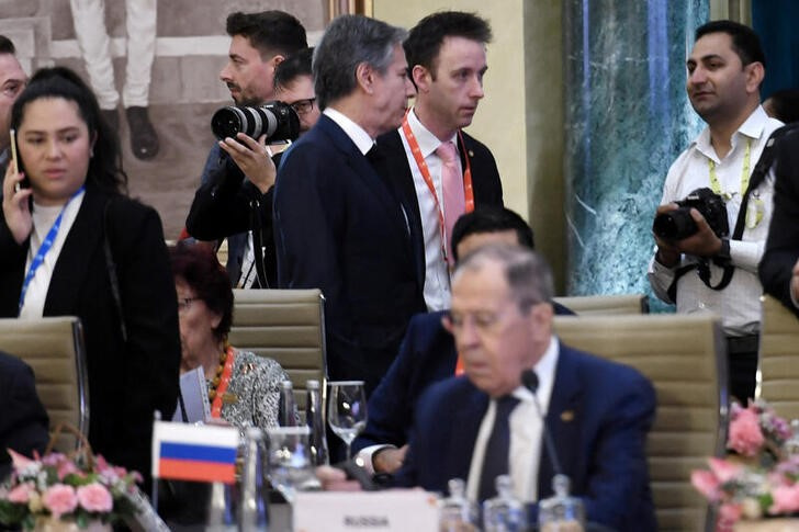 &copy; Reuters. El secretario de Estado de EEUU, Antony Blinken (al fondo) pasa por detrás del ministro de Relaciones Exteriores ruso, Sergei Lavrov (debajo), durante la reunión de cancilleres del G20 en Nueva Delhi, India. 2 marzo 2023. OLIVIER DOULIERY/Pool vía Reut