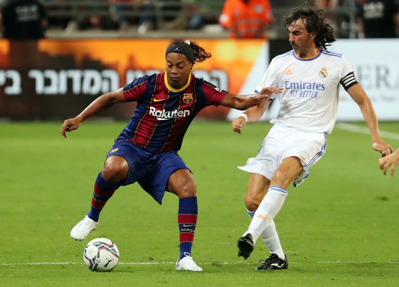 &copy; Reuters. FOTO DE ARCHIVO: El futbolista brasileño Ronaldinho (izquierda) y el español José Emilio Amavisca durante el partido de jugadores históricos del Fútbol Club Barcelona y el Real Madrid disputado en el estadio Bloomfield de Tel Aviv, Israel, el 20 de j