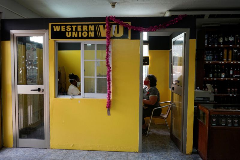 &copy; Reuters. FILE PHOTO: Odalys Paez sits inside a Western Union office to receive a remittance, in Havana, Cuba, October 28, 2020.  REUTERS/Alexandre Meneghini