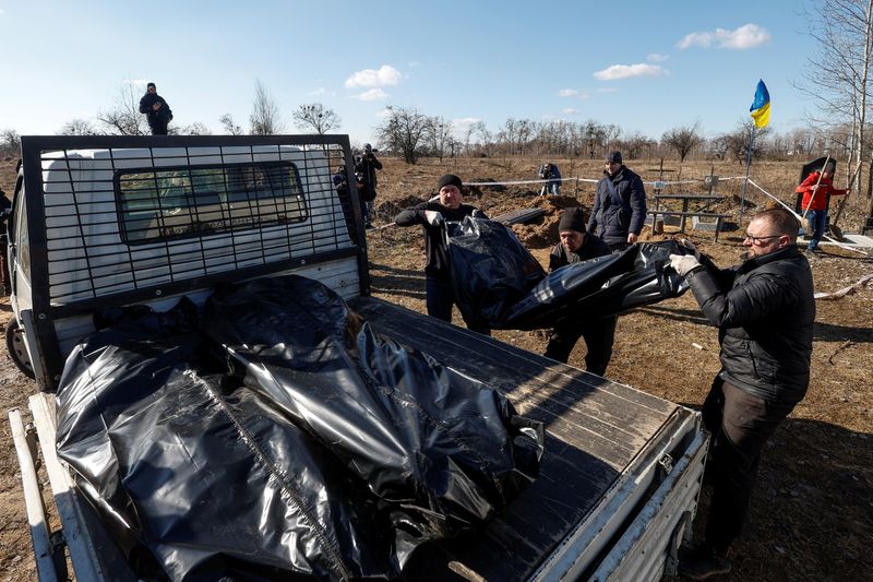 &copy; Reuters. Voluntarios transportan los cuerpos de las personas que fueron enterradas por un residente local durante la ocupación rusa de la ciudad de Borodyanka el año pasado, en medio del ataque de Rusia a Ucrania, después de una exhumación en el cementerio de 