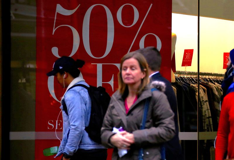 &copy; Reuters. FILE PHOTO: Shoppers walk past and stand outside a retail store displaying a sales sign in central Wellington, New Zealand, July 3, 2017. Picture taken July 3, 2017.   REUTERS/David Gray