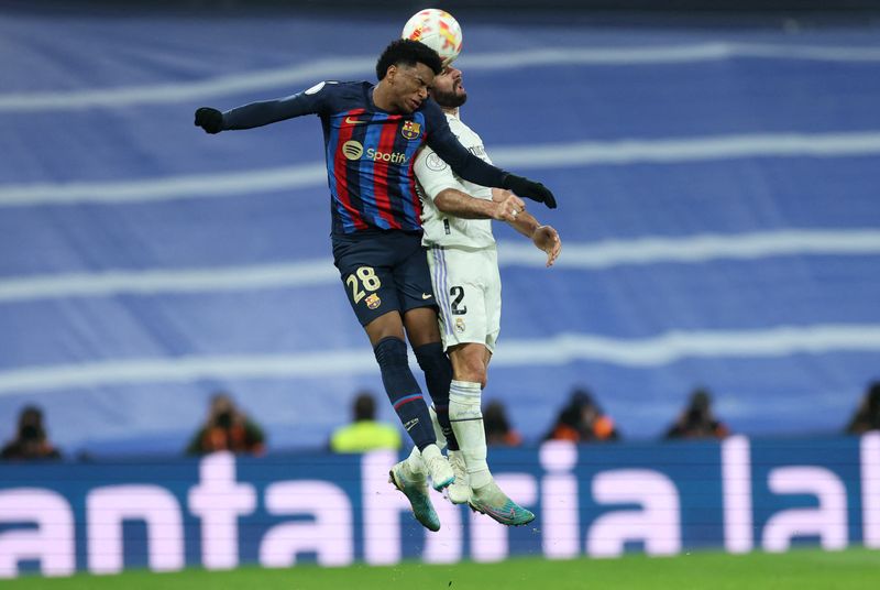 &copy; Reuters. Fútbol - Copa del Rey - Semifinal - Partido de ida - Real Madrid vs FC Barcelona - Santiago Bernabeu, Madrid, España - 2 de marzo de 2023. Alex Balde, del FC Barcelona, en acción con Dani Carvajal, del Real Madrid. REUTERS/Isabel Infantes