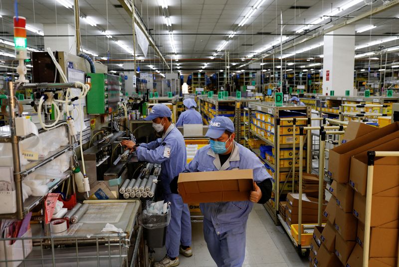 &copy; Reuters. Des employés travaillent sur une ligne de production de pièces mécaniques, au milieu de la maladie du coronavirus (COVID-19), dans une usine de SMC Corporation, lors d'une visite organisée pour les médias, à Pékin, en Chine. /Photo prise le 10 janv