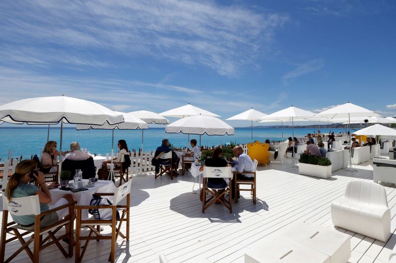 &copy; Reuters. FILE PHOTO: Customers enjoy a lunch on the terrace of a beach restaurant in Nice as cafes, bars and restaurants reopen after closing down for months amid the coronavirus disease (COVID-19) outbreak in France, May 19, 2021. REUTERS/Eric Gaillard