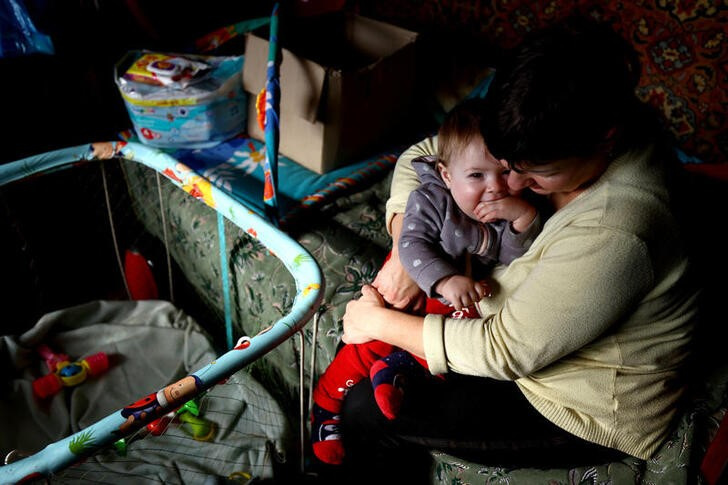 &copy; Reuters. La ucraniana Natalia Lukina abraza a su hija Kateryna, nacida durante la ocupación rusa, en Antonivka, región de Jersón, Ucrania. 23 febrero 2023. REUTERS/Lisi Niesner