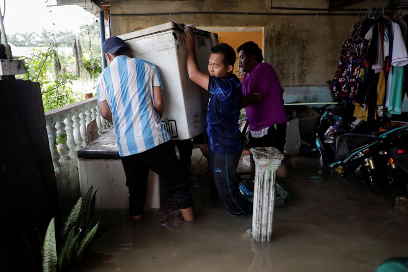 &copy; Reuters. People move a refrigerator from a flooded house, during a flood at Yong Peng, Johor, Malaysia March 4, 2023. REUTERS/Hasnoor Hussain