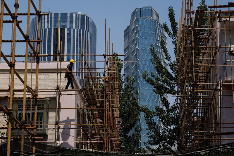 &copy; Reuters. FILE PHOTO: A worker walks on a scaffolding at a construction site of an apartment building under refurbishment in Beijing, China, July 20, 2022. REUTERS/Thomas Peter