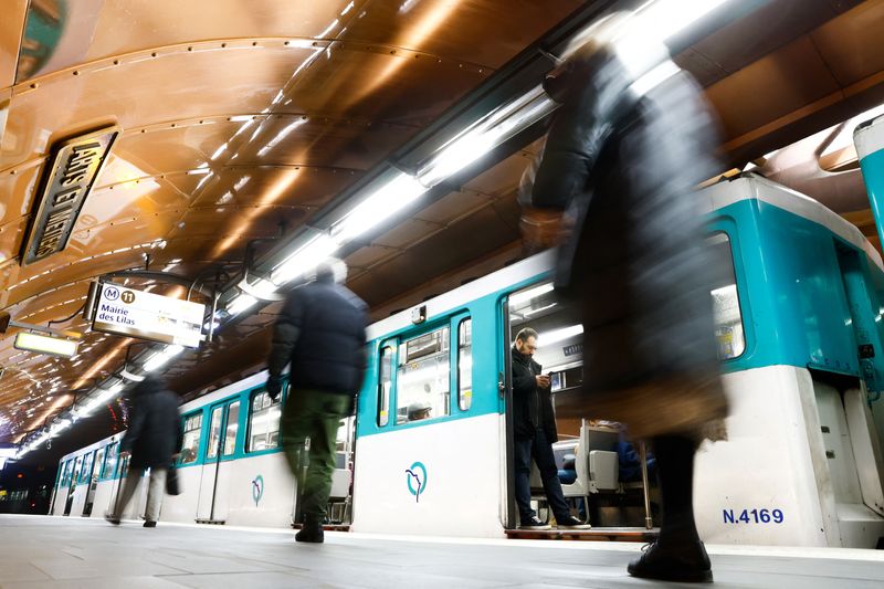 &copy; Reuters. Des passagers marchent à côté d'un métro exploité par la RATP à l'intérieur de la station Arts et Métiers à Paris, à la veille de la troisième journée nationale de grève et de protestations contre le plan de réforme des retraites du gouverne