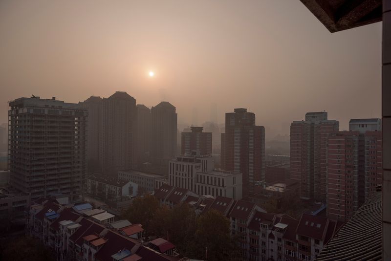 &copy; Reuters. FOTO DE ARCHIVO: El sol se eleva sobre la ciudad en una mañana con contaminación en Pekín, China, 18 de noviembre de 2021.  REUTERS/Thomas Peter