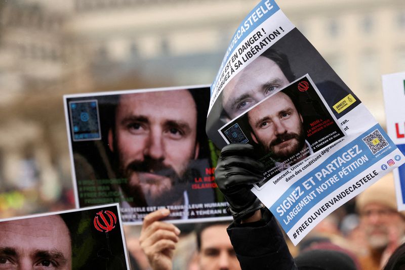 &copy; Reuters. FILE PHOTO: People hold pictures of Belgian aid worker Olivier Vandecasteele during a protest against his detention in Iran, as he was sentenced to 40 years in prison and 74 lashes on charges including spying, in Brussels, Belgium January 22, 2023. REUTER