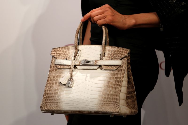 © Reuters. FILE PHOTO: A model carries a Hermes signature Birkin with Himalayan crocodile leather and diamonds, sold for $300,168 at a Christie's auction on May 30, 2016 which becomes the world's most expensive handbag, at a preview in Hong Kong, China May 4, 2016. REUTERS/Bobby Yip 