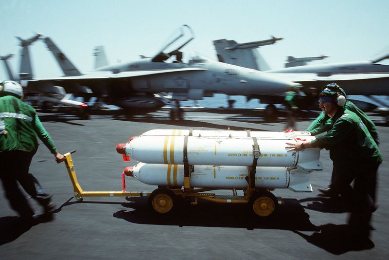 © Reuters. FILE PHOTO: U.S. Navy maintenance crewmen from Navy Attack Squadron 34 move a weapons skid loaded with Mark 20 Rockeye II cluster bombs across the flight deck of the nuclear-powered aircraft carrier USS Dwight D. Eisenhower in the Persian Gulf during the U.S. response to Iraq's invasion of Kuwait in this U.S. Navy handout photo from August 1, 1990. PH2 Kettenhoffen/U.S. Navy/U.S. National Archives via REUTERS  