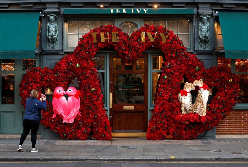 &copy; Reuters. A woman photographs a Valentines Day floral display attached to the facade of a restaurant in London, Britain, February 13, 2023.  REUTERS/Peter Nicholls