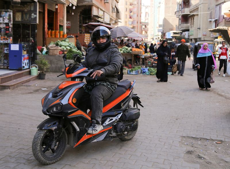 &copy; Reuters. إيمان العدوي على دراجتها النارية (السكوتر) في حي إمبابة بمدينة الجيزة بمصر يوم 21 فبراير شباط 2023. تصوير:هناء حبيب - رويترز.