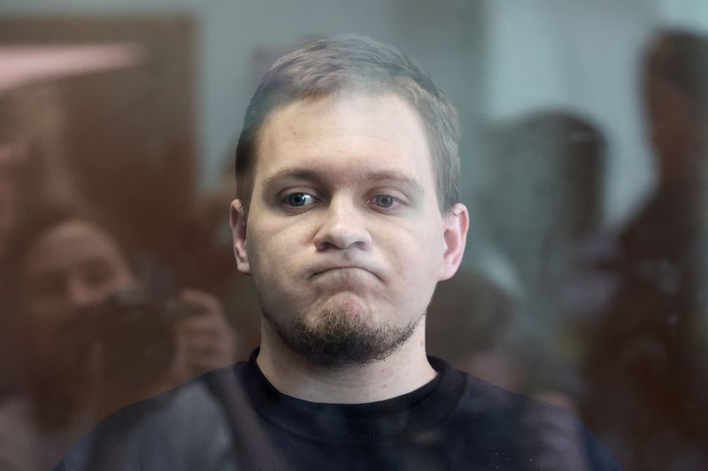 © Reuters. Russian opposition activist Dmitry Ivanov, accused of spreading false information about the Russian army in the course of Russia-Ukraine military conflict, reacts behind a glass wall of an enclosure for defendants as he attends a court hearing in Moscow, Russia, March 7, 2023. REUTERS/Stringer