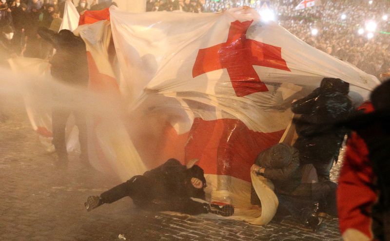 © Reuters. Police use a water cannon to disperse protesters during a rally against the 