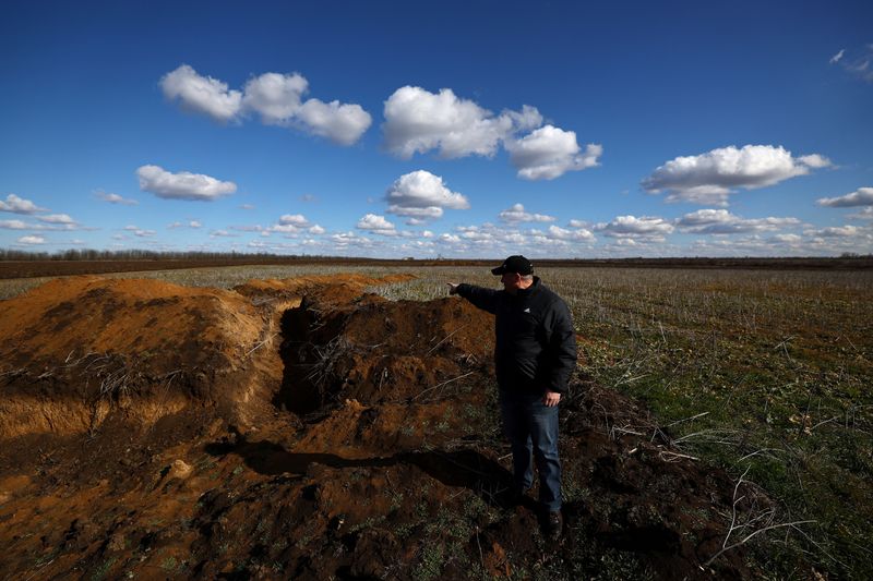 &copy; Reuters. FILE PHOTO: Grain farmer Oleksandr Klepach points at trenches in his field, amid Russia's invasion of Ukraine, in Snihurivka, southeast Ukraine, February 20, 2023. REUTERS/Lisi Niesner