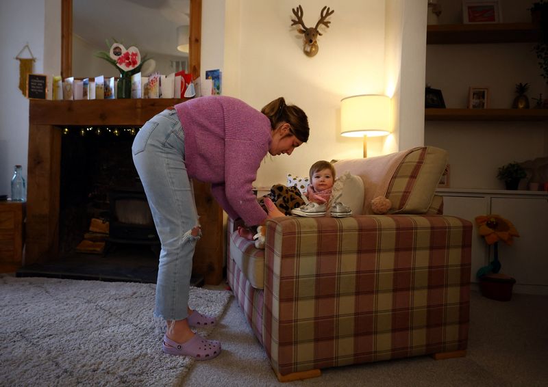 &copy; Reuters. FILE PHOTO: Louise Sharples, 35, dresses her daughter Sunnie, 1, in their home in Clitheroe, East Lancashire, Britain, March 1, 2023. REUTERS/Hannah McKay