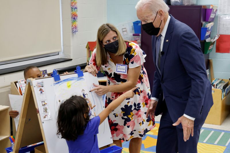 © Reuters. FILE PHOTO: U.S. President Joe Biden, flanked by Allison Hessemer, a preschool teacher, speaks with a child as he visits East End Elementary School in North Plainfield, New Jersey, U.S., October 25, 2021. REUTERS/Jonathan Ernst