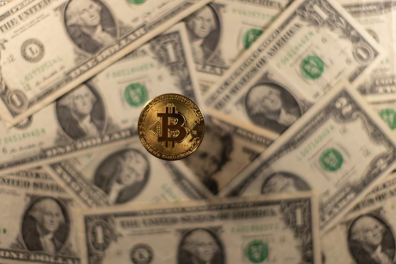 © Reuters. Representation of virtual cryptocurrency Bitcoin is placed on U.S. Dollar banknotes in this illustration taken November 28, 2021. REUTERS/Dado Ruvic/Illustration