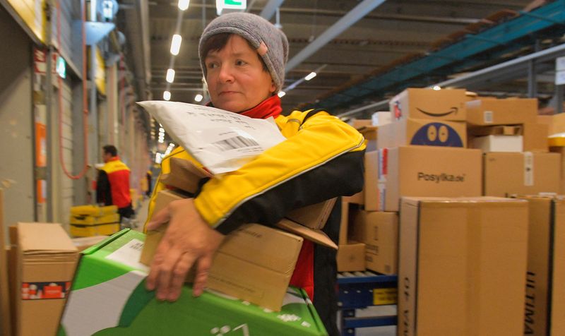 &copy; Reuters. FILE PHOTO: Postwoman Susann Krosse fetches her parcels from a distribution centre of German postal and logistics group Deutsche Post DHL in Ottendorf-Okrilla near Dresden, Germany, December 15, 2022. REUTERS/Matthias Rietschel/File Photo