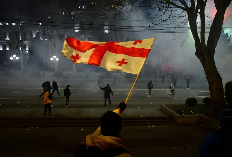 &copy; Reuters. A demonstrators waves a Georgian flag during a protest against a draft law on "foreign agents", which critics say represents an authoritarian shift and could hurt Georgia's bid to join the European Union, in Tbilisi, Georgia, March 9, 2023. REUTERS/Zurab 