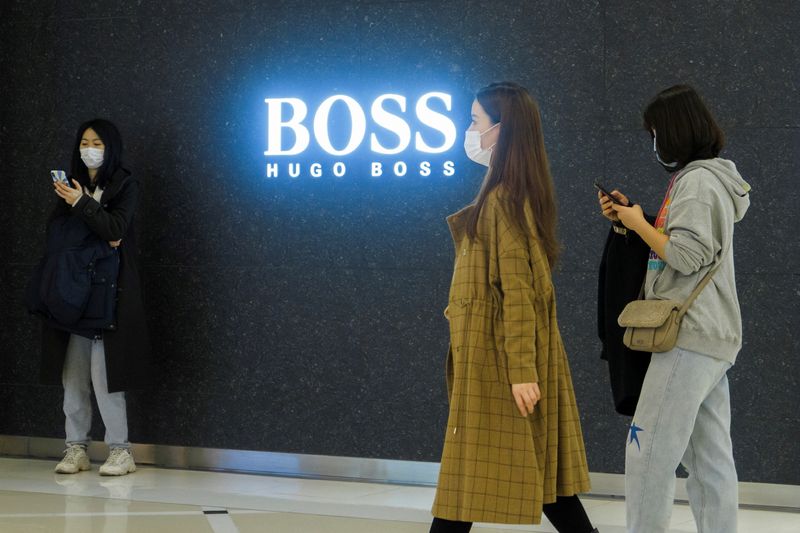 &copy; Reuters. FOTO DE ARCHIVO: Varias personas pasan por delante de una tienda de la casa de moda alemana Hugo Boss en Pekín, China, 27 de marzo de 2021.  REUTERS/Thomas Peter