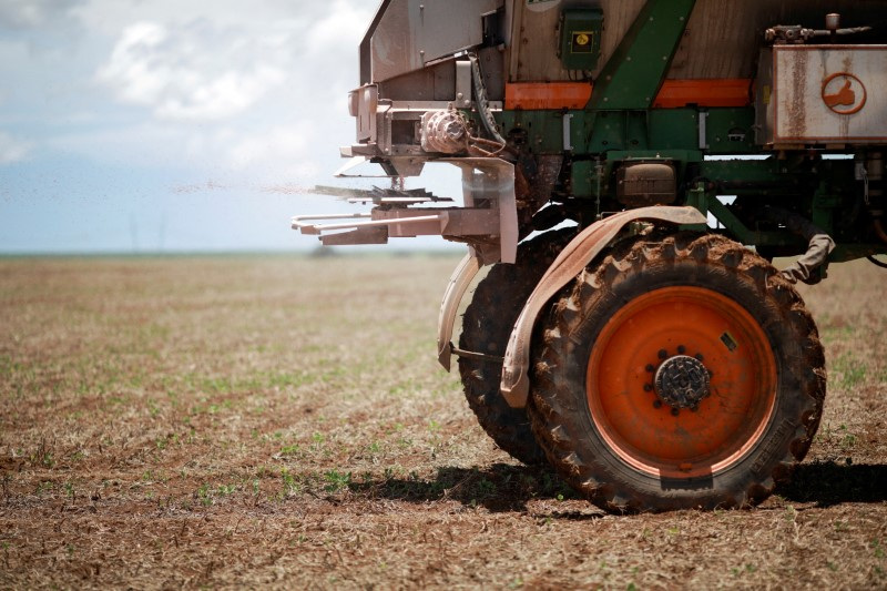 © Reuters. FILE PHOTO: An agricultural worker drives a tractor spreading fertilizer in a soybean field, near Brasilia, Brazil February 15, 2022.REUTERS/Adriano Machado/File Photo