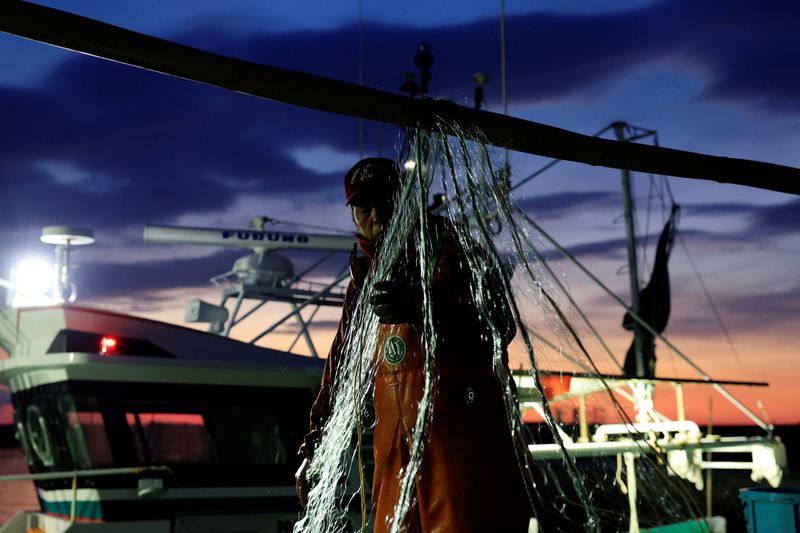 © Reuters. Fisherman Haruo Ono, 71, untangles nets after returning from work at sea for the night, at Tsurishihama fishing port in Shinchimachi, about 55 km away from the disabled Fukushima Dai-ichi nuclear power plant, in Fukushima Prefecture, Japan, March 1, 2023. The Tokyo Electric Power Co (Tepco), which runs the crippled nuclear power station, plans to soon start releasing into the sea more than a million tons of radioactive water from the plant that was used to cool the reactors in the aftermath of the March 11, 2011 tsunami that set off explosions and meltdowns, released radiation over a wide swathe and shut down fishing for more than a year due to worries about radiation. 