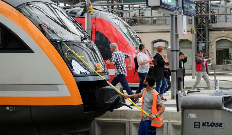 &copy; Reuters. FILE PHOTO: A service employee cleans the front window of a train as passengers walk on a platform at Dresden main station after Deutsche Bahn rail operator and other local transport operators offered a special nine-euro ticket to be used nationwide for a