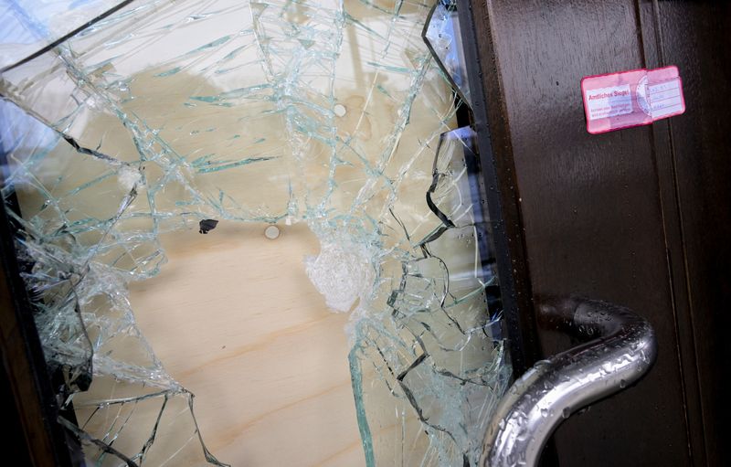 © Reuters. A seal is seen on a door with a broken glass pane at a building housing a Kingdom Hall of Jehovah's Witnesses where a deadly shooting took place, in Hamburg, northern Germany, March 10, 2023. REUTERS/Fabian Bimmer