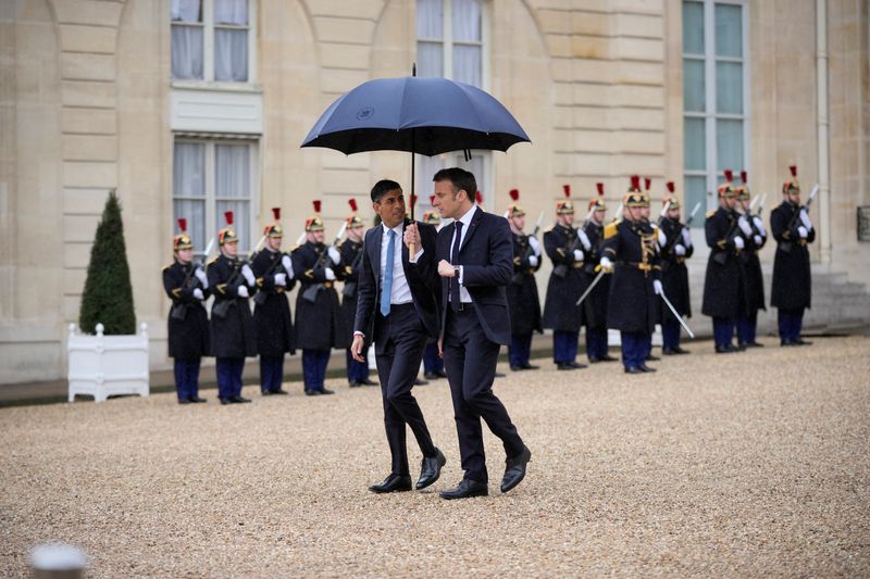 &copy; Reuters. French President Emmanuel Macron, uses an umbrella to protect Britain's Prime Minister Rishi Sunak after a French-British summit at the Elysee Palace in Paris, France, Friday, March 10, 2023. French President Emmanuel Macron and British Prime Minister Ris