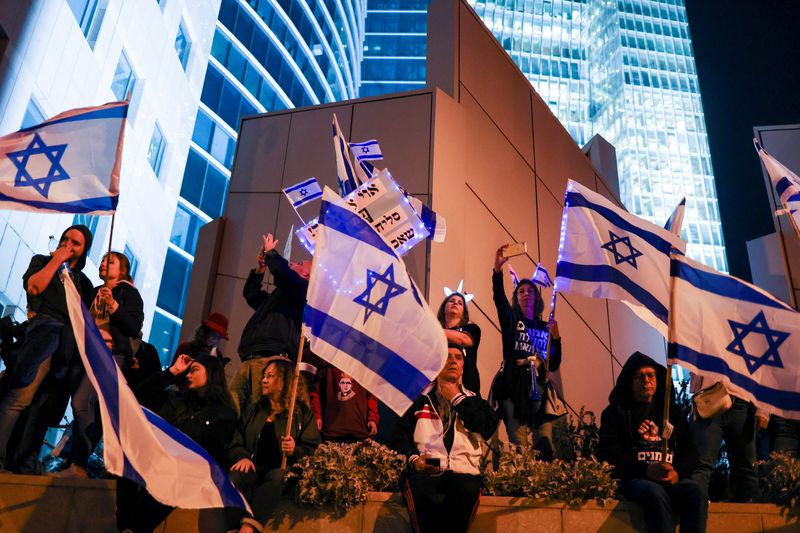 &copy; Reuters. People hold Israeli flags during a demonstration as Israeli Prime Minister Benjamin Netanyahu's nationalist coalition government presses on with its contentious judicial overhaul, in Tel Aviv, Israel, March 11, 2023. REUTERS/Nir Elias