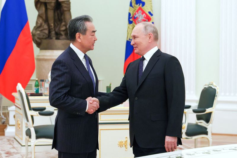 &copy; Reuters. Russia's President Vladimir Putin shakes hands with China's Director of the Office of the Central Foreign Affairs Commission Wang Yi during a meeting in Moscow, Russia February 22, 2023. Sputnik/Anton Novoderezhkin/Pool via REUTERS/File Photo