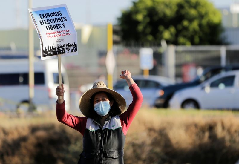 &copy; Reuters. Imagen de archivo. Un activista sostiene un cartel durante una protesta frente a la planta de camionetas de General Motors mientras los trabajadores votan para elegir un nuevo sindicato bajo una reforma laboral que sustenta un nuevo acuerdo comercial con 