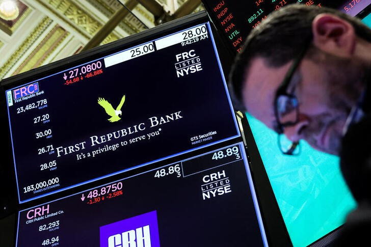 &copy; Reuters. Un trader guarda le quotazioni accanto a uno schermo con informazioni sulla First Republic Bank alla Borsa di New York, negli Stati Uniti. 13 marzo 2023. REUTERS/Brendan McDermid