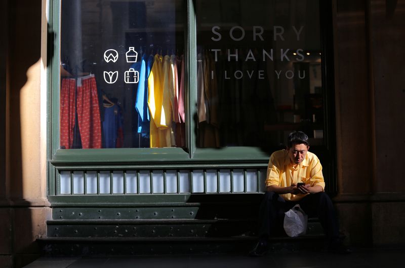 &copy; Reuters. FILE PHOTO: A shopper uses his phone as he sits outside a small retail clothing shop in Sydney, Australia, May 10, 2017. Picture taken May 10, 2017.     REUTERS/Steven Saphore