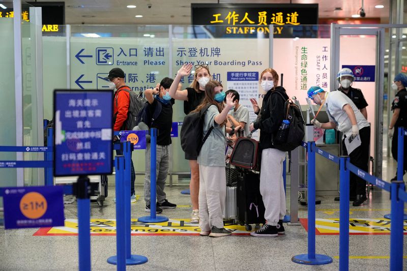 &copy; Reuters. سيدة أمريكية وابنتاها تودعن أصدقائهن قبل مغادرة مطار بودونغ بمدينة شنغهاي الصينية في 27 يونيو حزيران 2022. تصوير : ألي سونج - رويترز . 