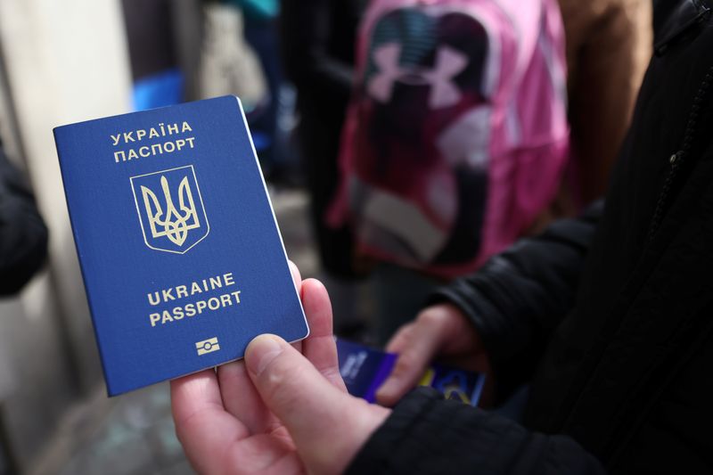 &copy; Reuters. Un ukrainien montre son passeport devant le bureau de l'immigration à Bruxelles, en Belgique. /Photo prise le 13 mars 2022/REUTERS/Johanna Geron
