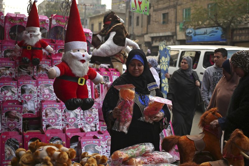 &copy; Reuters. امرأة تنظر إلى دمية في متجر لبيع مستلزمات الكريسماس بالقاهرة. صورة من أرشيف رويترز.