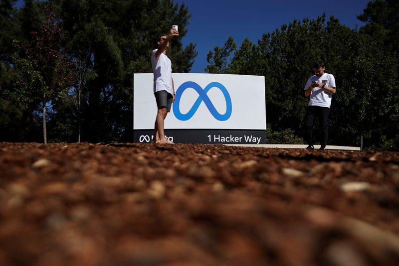 © Reuters. FILE PHOTO: A man takes a selfie in front of a sign of Meta at its headquarters in Menlo Park, California, U.S. October 28, 2021. REUTERS/Carlos Barria/File Photo