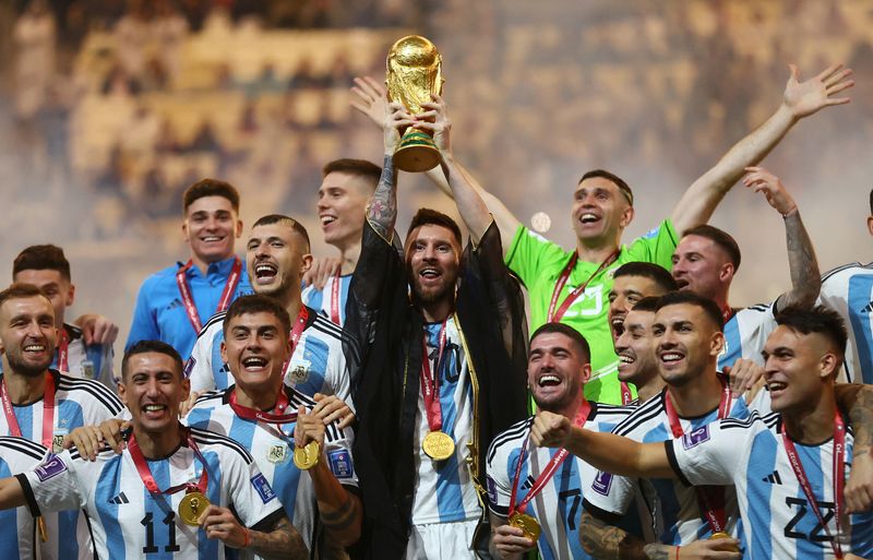 &copy; Reuters. FOTO DE ARCHIVO: Fútbol Fútbol - Copa Mundial de la FIFA Qatar 2022 - Final - Argentina vs Francia - Estadio Lusail, Lusail, Qatar - 18 de diciembre de 2022. El argentino Lionel Messi levanta el trofeo de la Copa Mundial junto a sus compañeros de equip
