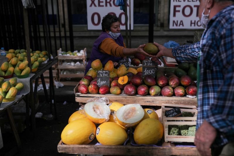 &copy; Reuters. FILE PHOTO: A man hands over a mango to the saleswoman at a weekly street market in Rio de Janeiro, Brazil July 8, 2021. REUTERS/Amanda Perobelli/File Photo