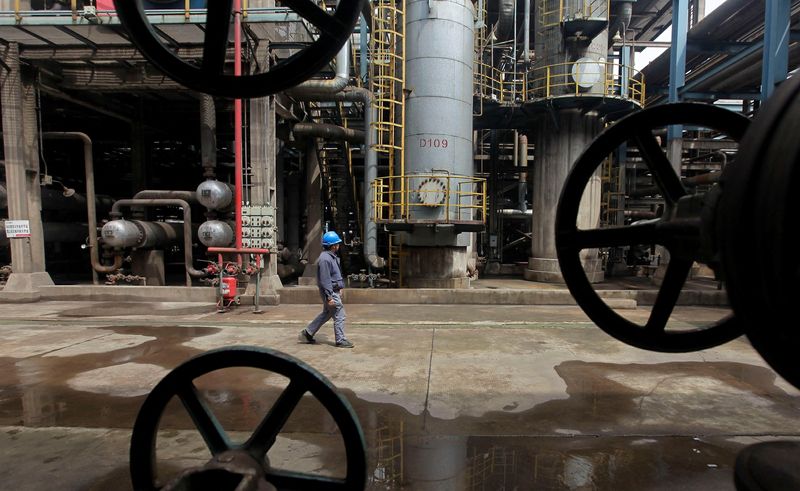 &copy; Reuters. أحد العمال يسير قريبا من أنابيب النفط في إحدى المصافي النفطية في ووهان الصينية. صورة من أرشيف رويترز 