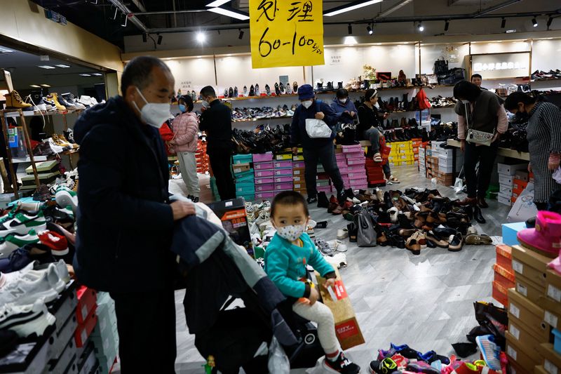 &copy; Reuters. FOTO DE ARCHIVO: Los clientes compran en una tienda de zapatos durante una venta de liquidación antes del Año Nuevo Lunar chino, en un centro comercial en Beijing, China 15 de enero 2023. REUTERS/Tingshu Wang
