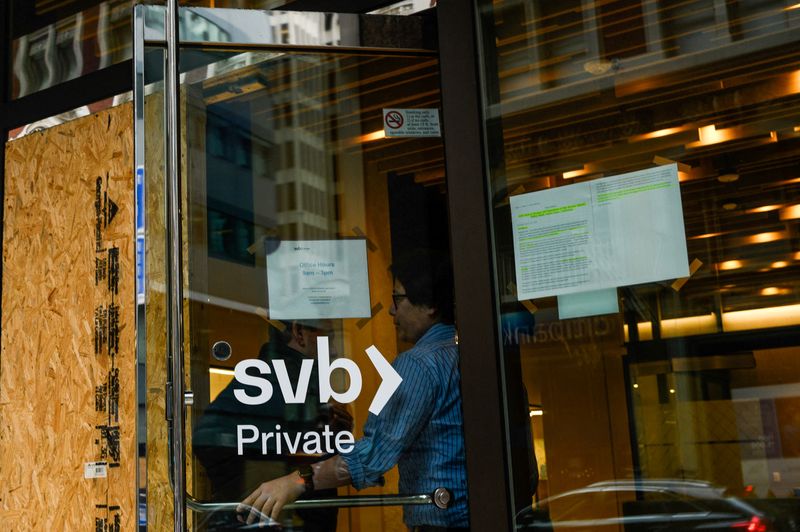 &copy; Reuters. A Silicon Valley Bank employee holds the door for a customer at the bank's branch office in downtown San Francisco, California, U.S., March 13, 2023. REUTERS/Kori Suzuki