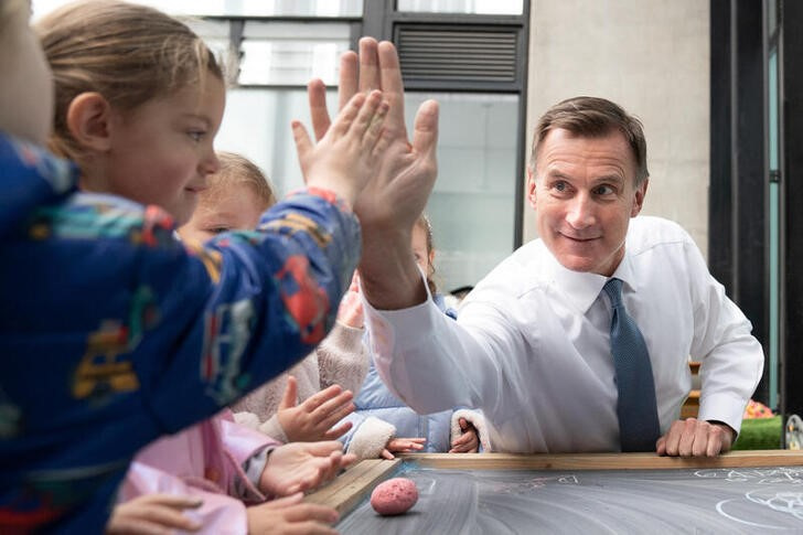 © Reuters. Chancellor of the Exchequer Jeremy Hunt meets children during a visit to Busy Bees Battersea Nursery in south London, after delivering his Budget earlier, in London, Britain. Picture date: Wednesday March 15, 2023. Stefan Rousseau/Pool via REUTERS