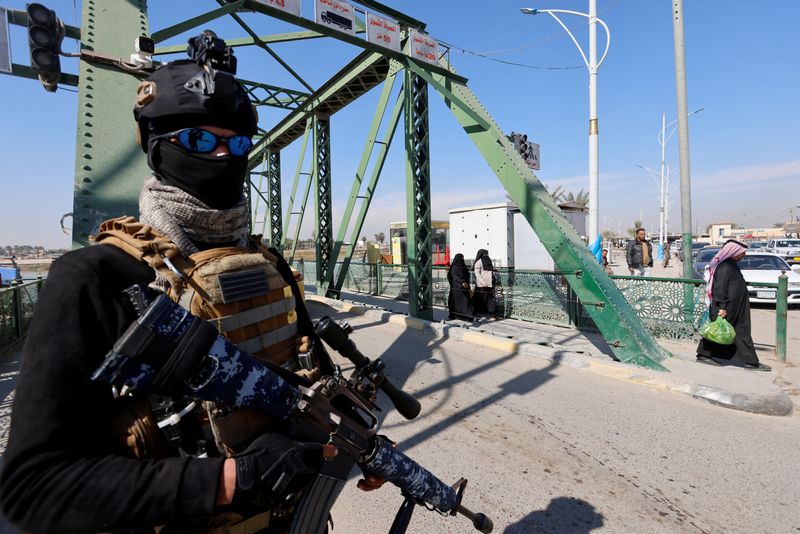&copy; Reuters. أحد أفراد قوات الأمن العراقية يقف بالقرب من الجسر الذي شهد مقتل أربعة متعاقدين من شركة الأمن الأمريكية بلاك ووتر عام 2004 في الفلوجة يوم 20 فبر