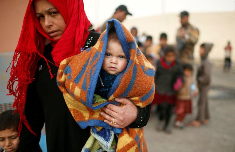 &copy; Reuters. FOTO DE ARCHIVO: Una mujer y un bebé iraquíes desplazados de sus hogares por la guerra al oeste de Mosul, Irak, el 13 de marzo de 2017. REUTERS/Suhaib Salem